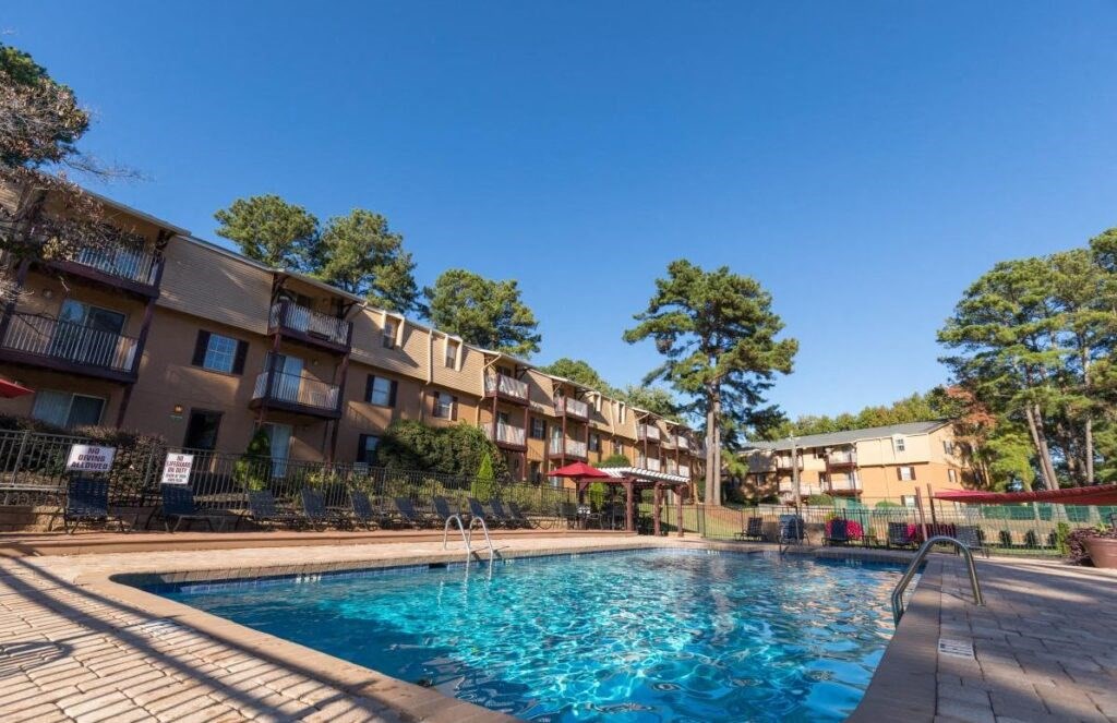 a swimming pool with apartments in the background