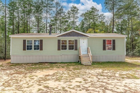 a small green house with a staircase in front of it