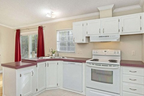 a white kitchen with white appliances and white cabinets