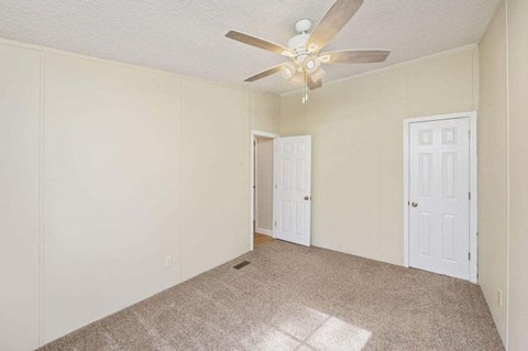 the living room of an empty house with a ceiling fan