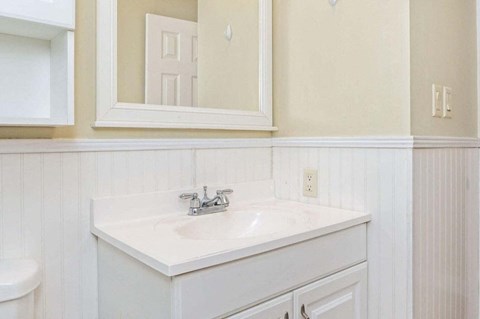 a white bathroom with a sink and a mirror