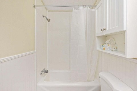 a white bathroom with a shower and a sink