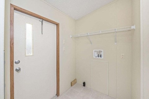 an empty room with a door to a bathroom with a shower