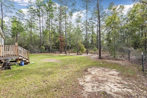 the backyard of a house with a deck and trees
