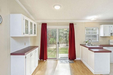 a kitchen with white cabinets and a sliding glass door