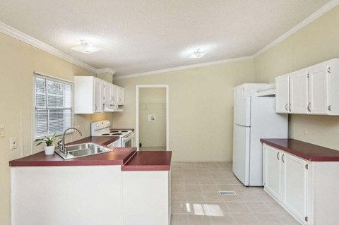 a kitchen with white cabinets and a sink and a refrigerator