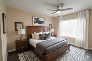 A bedroom with a bed, nightstands, and a ceiling fan.