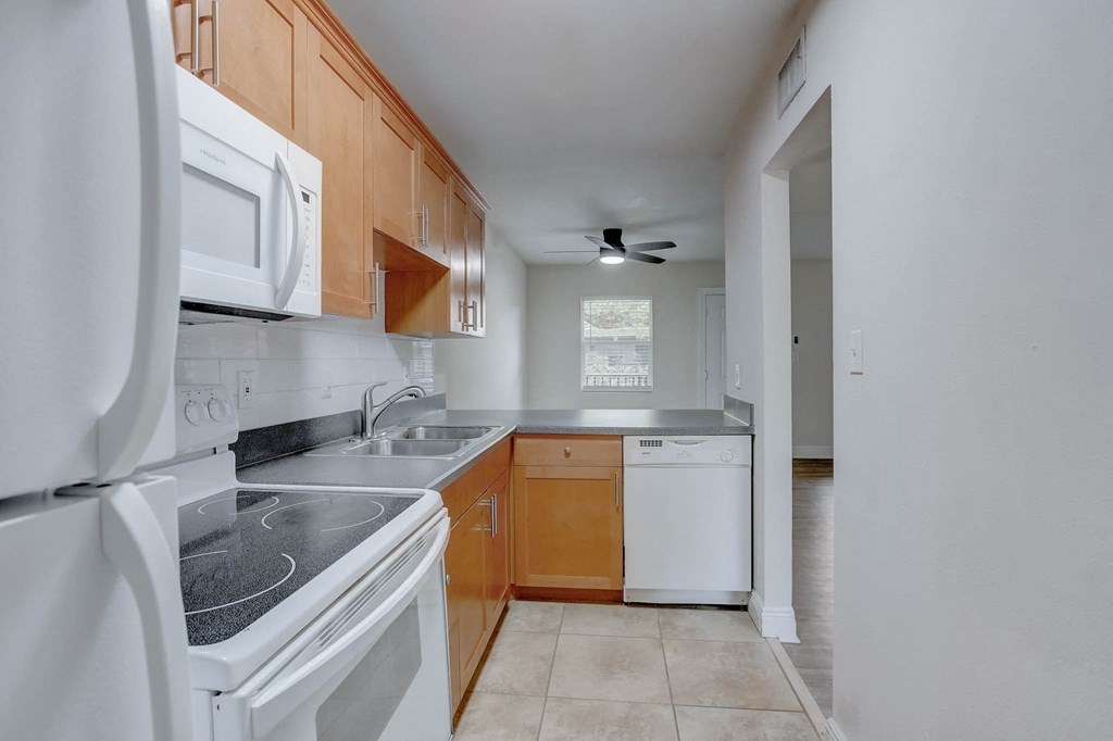 a kitchen with white appliances and wooden cabinets