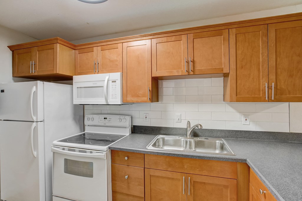 a kitchen with white appliances and wooden cabinets
