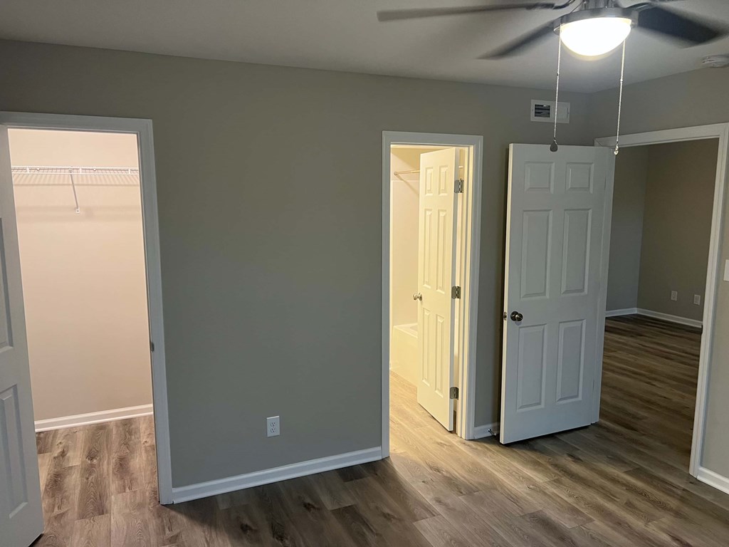 A room with a ceiling fan and two doors.