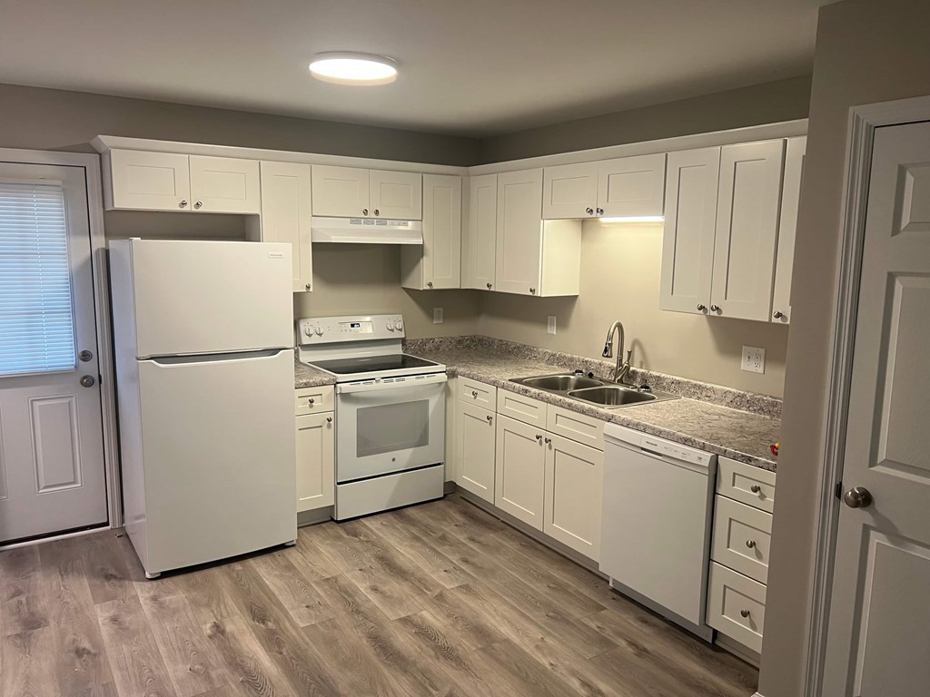 A kitchen with white appliances and cabinets.