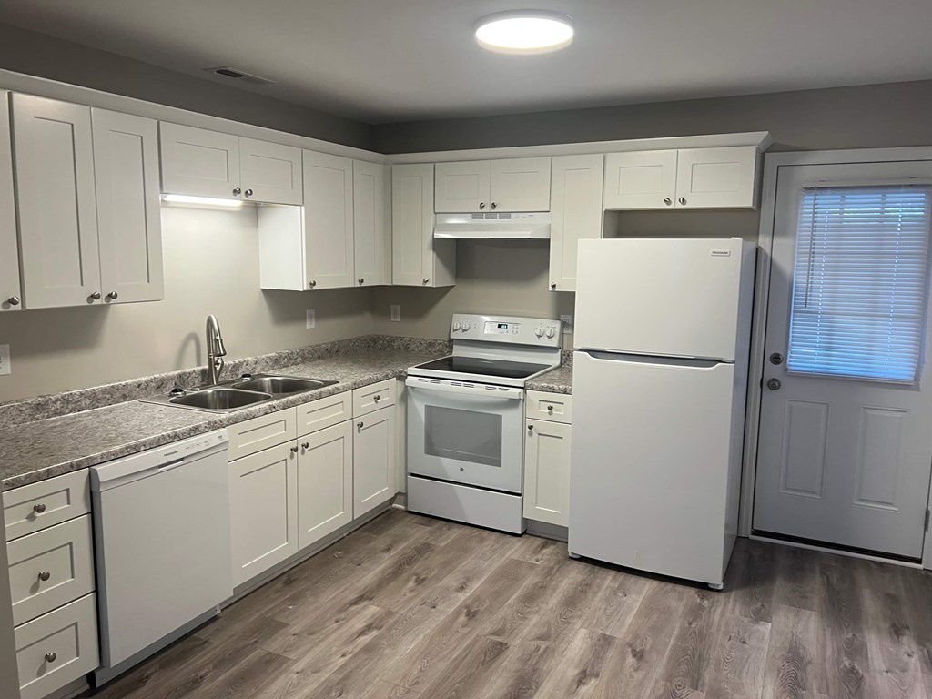 A kitchen with white appliances and cabinets.