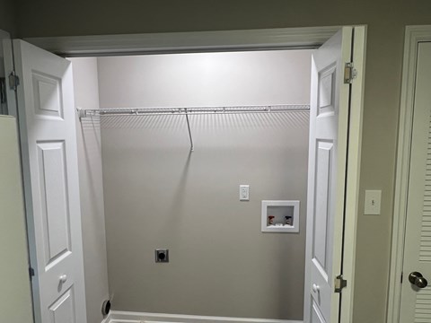 A white closet with a shelf and a hanger.