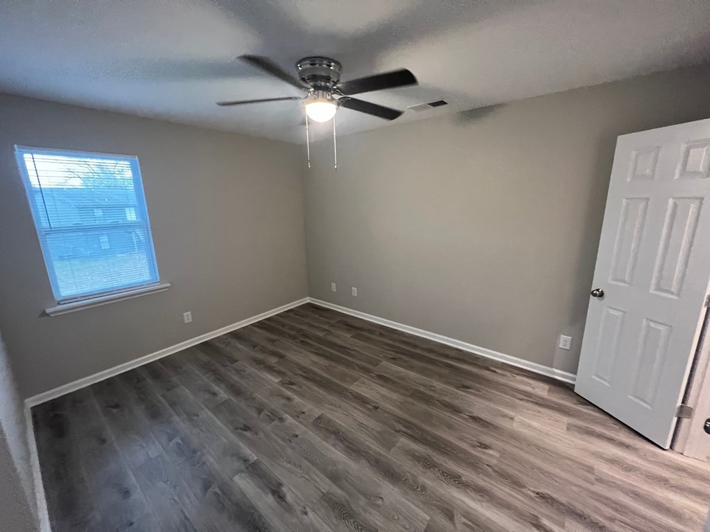 A room with a ceiling fan and a window.