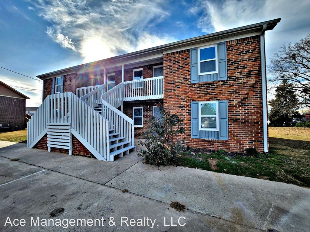A brick house with a white staircase in front.