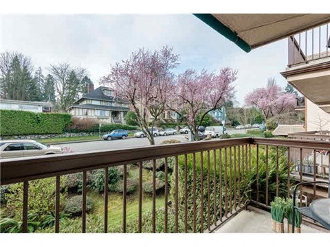 a balcony overlooking a street with flowering trees