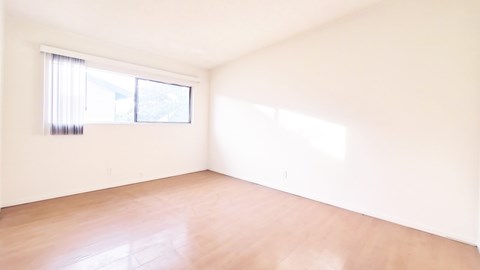 A room with a window and wooden floor.