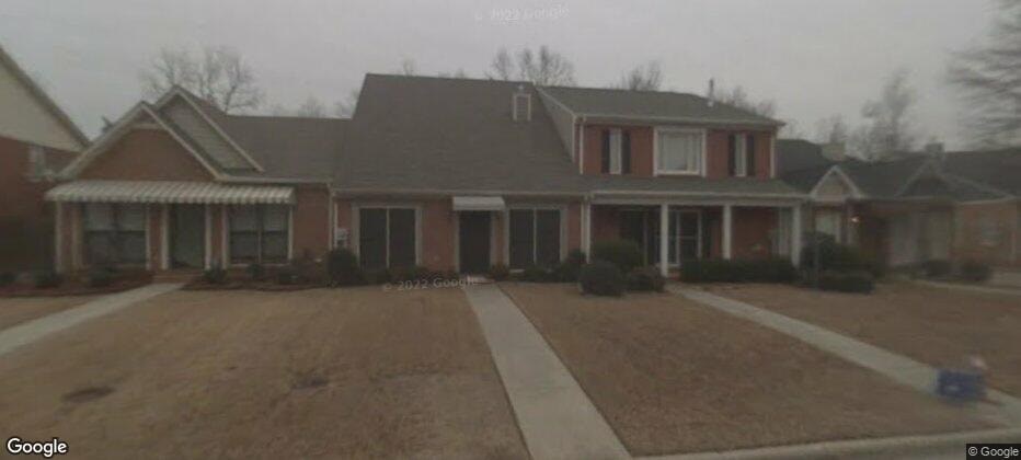 A house with a red brick exterior and a grey roof.