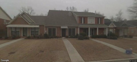 A house with a red brick exterior and a grey roof.