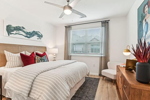 A bedroom with a large bed and a painting on the wall.