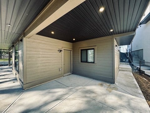 the garage of a house with a door and a sidewalk