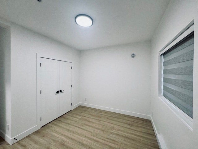 an empty room with white walls and a window