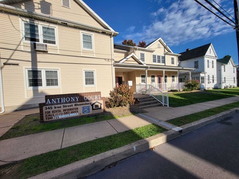 a house with a sign in front of it on a sidewalk