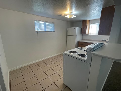 A kitchen with a white refrigerator and a white stove top oven.
