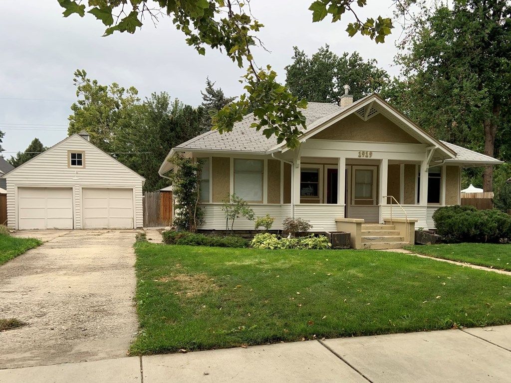 A house with a white garage door and a brown door.