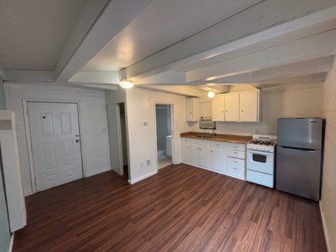 A kitchen with white cabinets and a wooden countertop.
