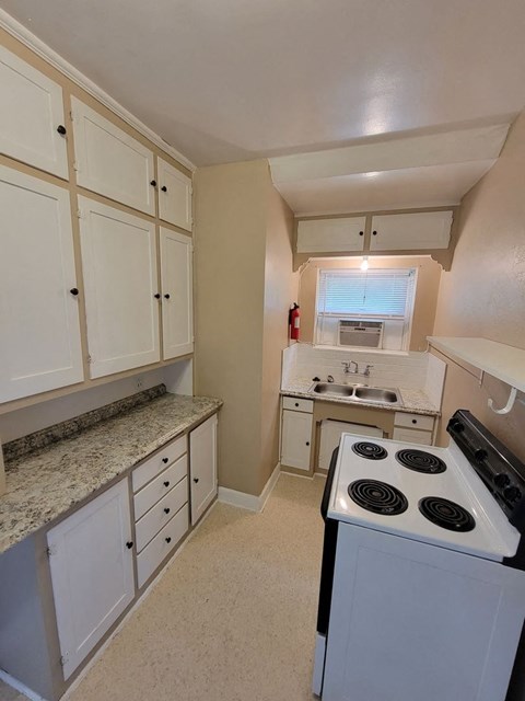 a kitchen with white cabinets and a stove top oven