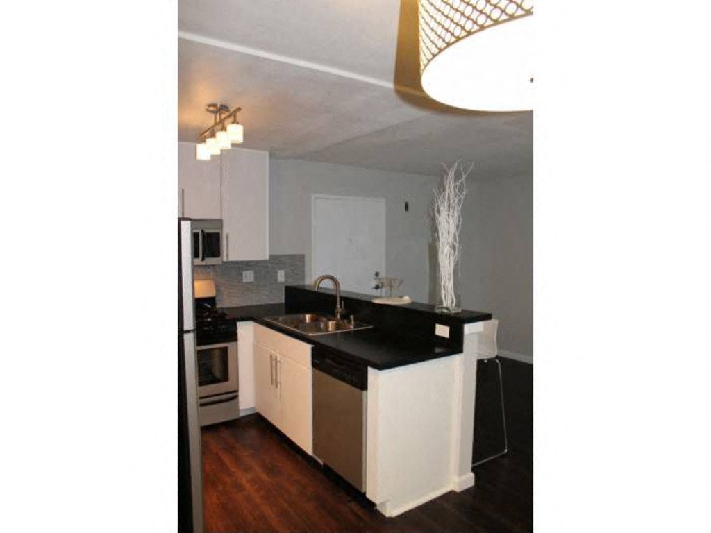 a kitchen with white cabinets and a black counter top