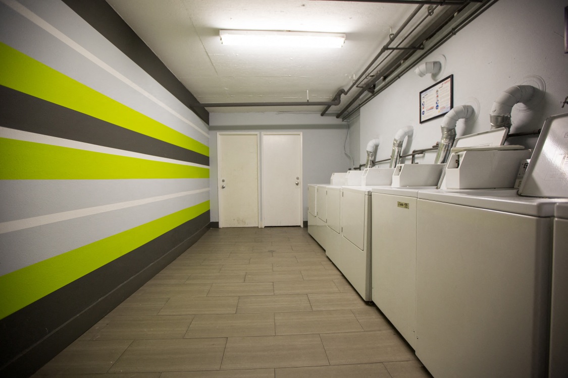 a laundromat with a row of sinks and washing machines