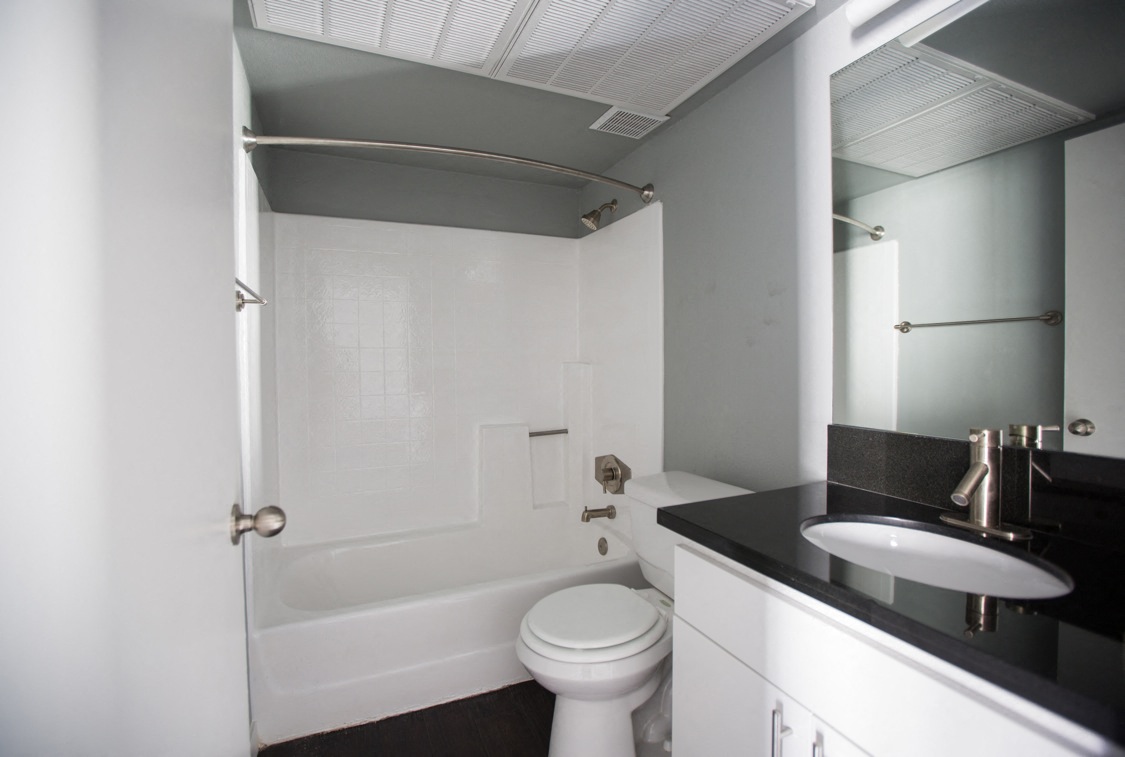 a white bathroom with a white toilet and a sink