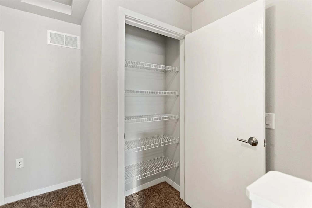 a pantry/closet with built-in shelving in a home at Muskego School Apartments