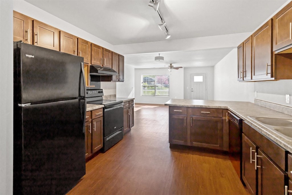 A large kitchen with efficient appliances, ample cabinetry, and natural light at Muskego School Apartments