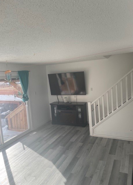 A living room with a television and a staircase.