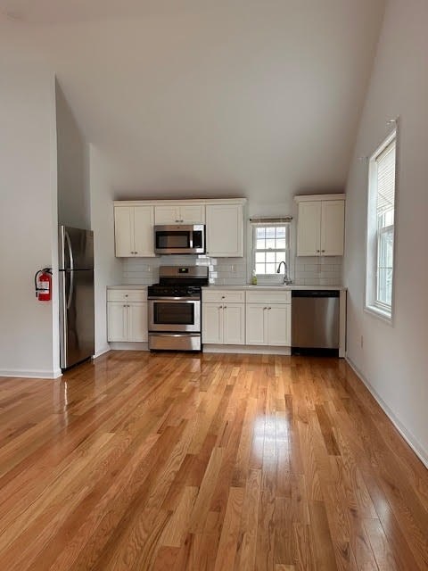 A kitchen with white cabinets and a wooden floor.