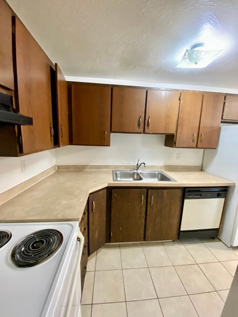 A kitchen with brown cabinets and a white stove.