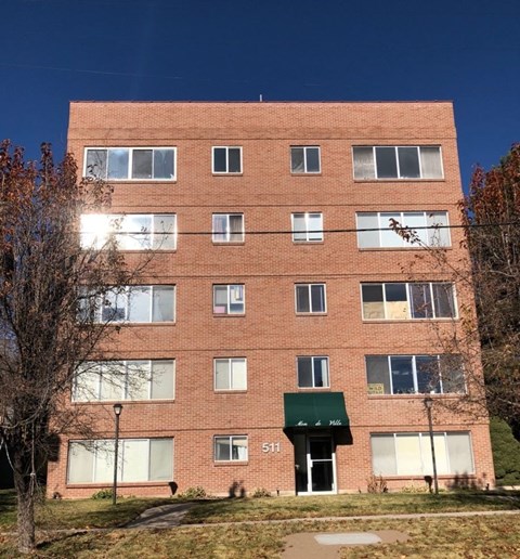 A red brick building with a green awning and the number 511 on it.