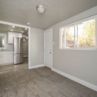 A kitchen with white cabinets and a refrigerator.