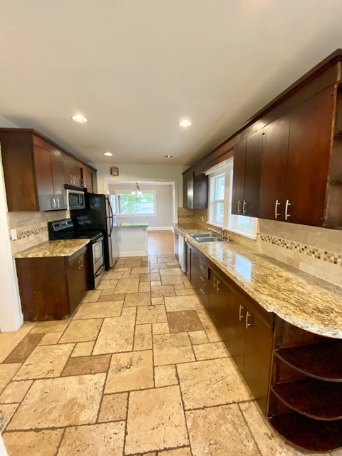 a kitchen with marble counter tops and wooden cabinets