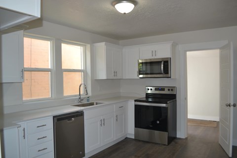 a kitchen with white cabinets and stainless steel appliances