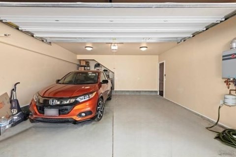 A red Honda car is parked in a garage.