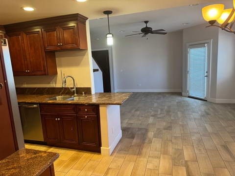A kitchen with wooden cabinets and a marble countertop.