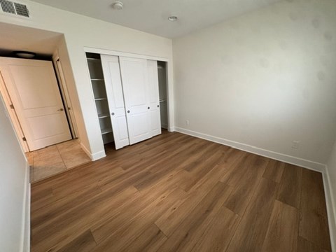 A room with wooden flooring and white walls.