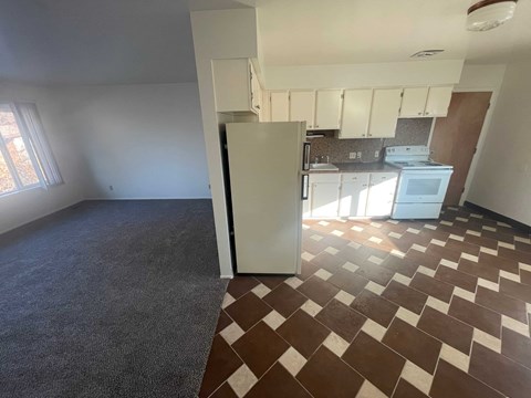 A kitchen with brown and white tiles on the floor.