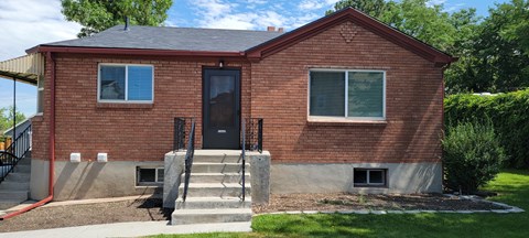 A red brick house with a black door and windows.