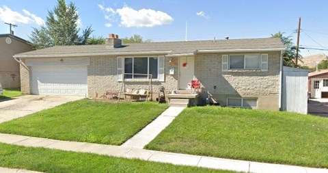 A house with a white garage door and a brown roof.