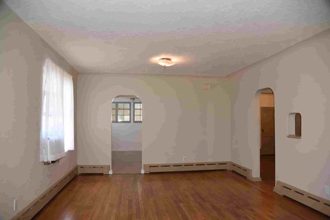an empty living room with white walls and wood floors